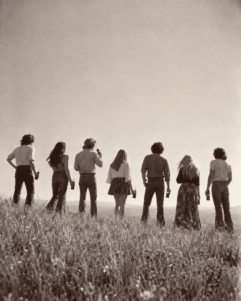 Young people on a hilltop holding Coca-Cola bottles (AI-generated image)
